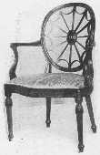 The wheel back design was often used by Adam. The arms, the curve of the seat and carving, the tapering reeded legs, and the angle of the back legs should all be noticed.