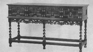 This Jacobean buffet is finely reproduced with the exception of the spiral carving of the legs, which is too sharp and thin, and gives the appearance of inadequate support. The split spindle ornament was much used on furniture of the period.