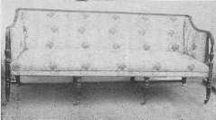 An admirable example of the Sheraton style mahogany settee with original silk covering.