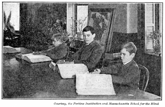 A photograph of boys touch-reading a large book