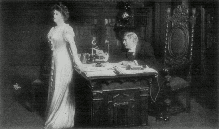 [Photo, from the play, of Mr. Ryder discussing his son with Miss Green.]