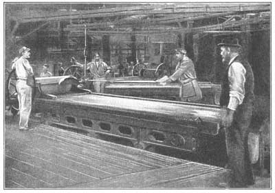 FIG. 20.—Molten glass being rolled into a form suitable for window panes.