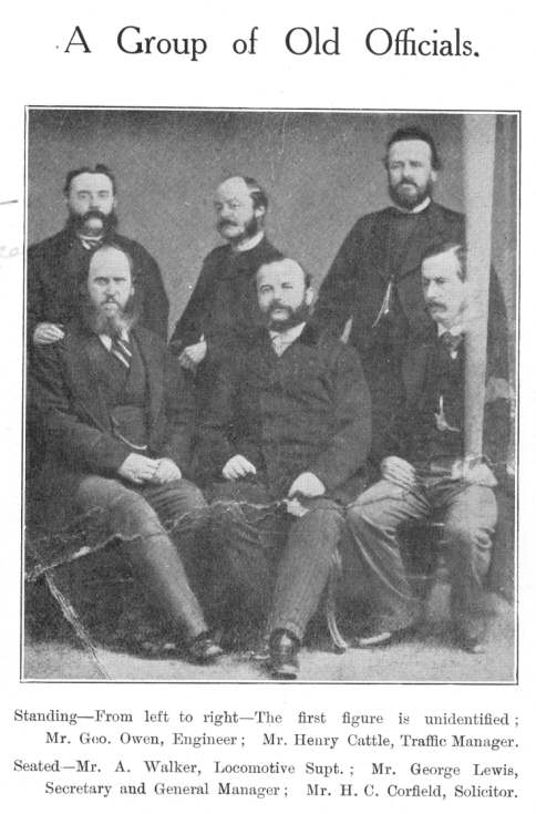 A Group of Old Officials.  Standing—From left to right—The first figure is unidentified; Mr. Geo. Owen, Engineer; Mr. Henry Cattle, Traffic Manager.  Seated—Mr. A. Walker, Locomotive Supt.; Mr. George Lewis, Secretary and General Manager; Mr. H. C. Corfield, Solicitor