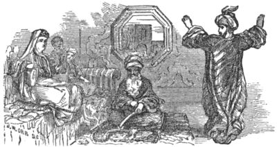 A seated woman watches a man standing with his arms raised. An older man sits on the floor between them