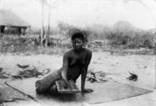 A SANKURU WOMAN PLAYING NATIVE DRAUGHTS