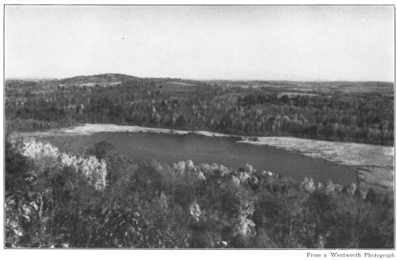 LONGFELLOW POND LIES IN THE HOLLOW OF THE WOODS