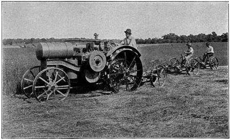 Tractor pulling two mowing machines