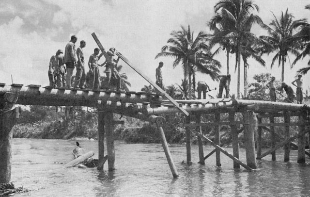 ENGINEER TROOPS of the 13th Engineer Battalion rebuild a bridge near Burauen.