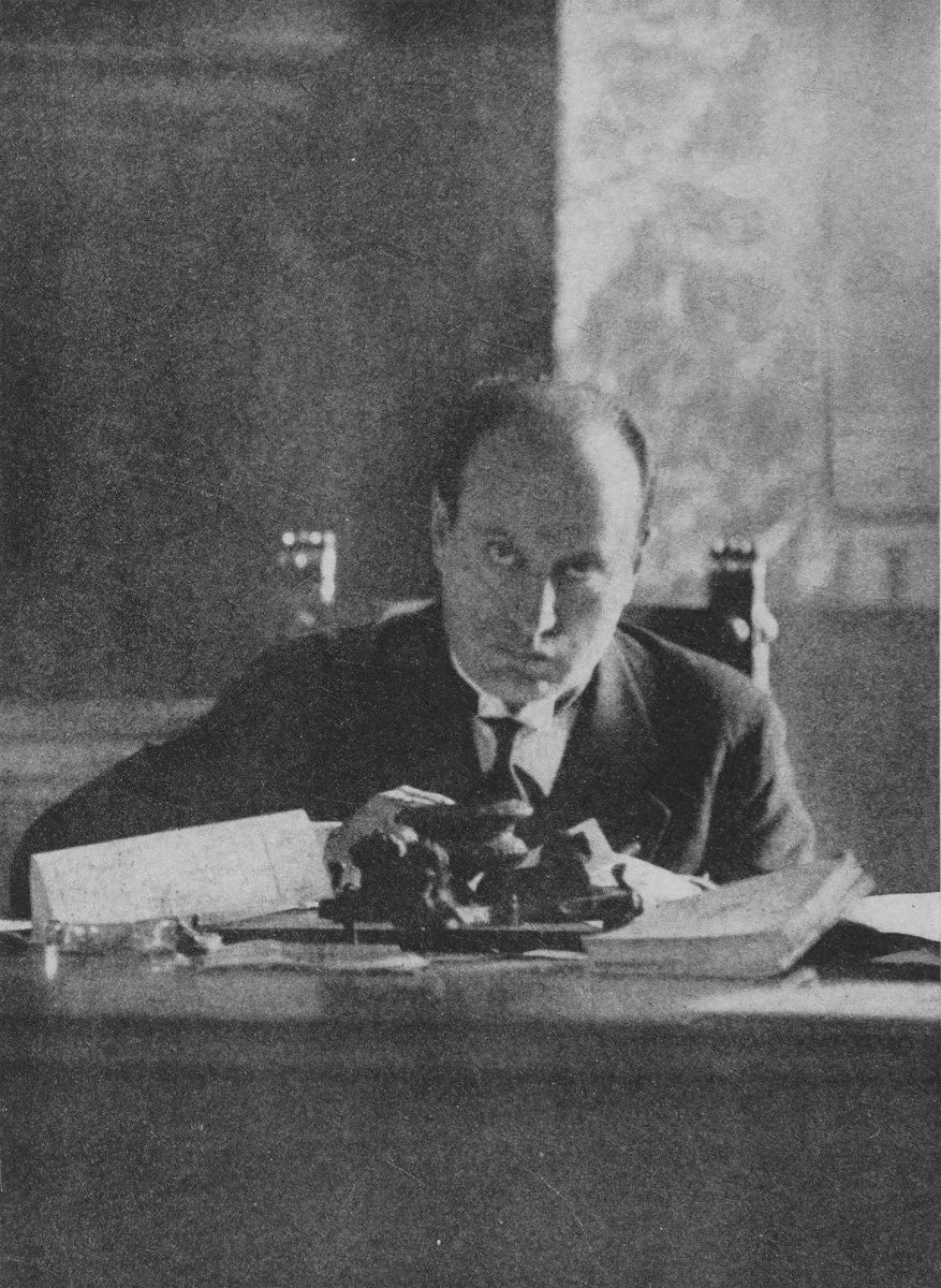 Mussolini sitting in chair behind office desk