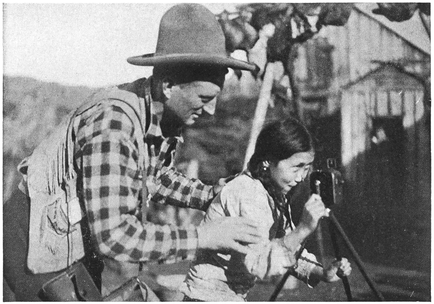 Carl Shows a South Greenland Youngster How to Use a Pathex Motion Picture Camera.